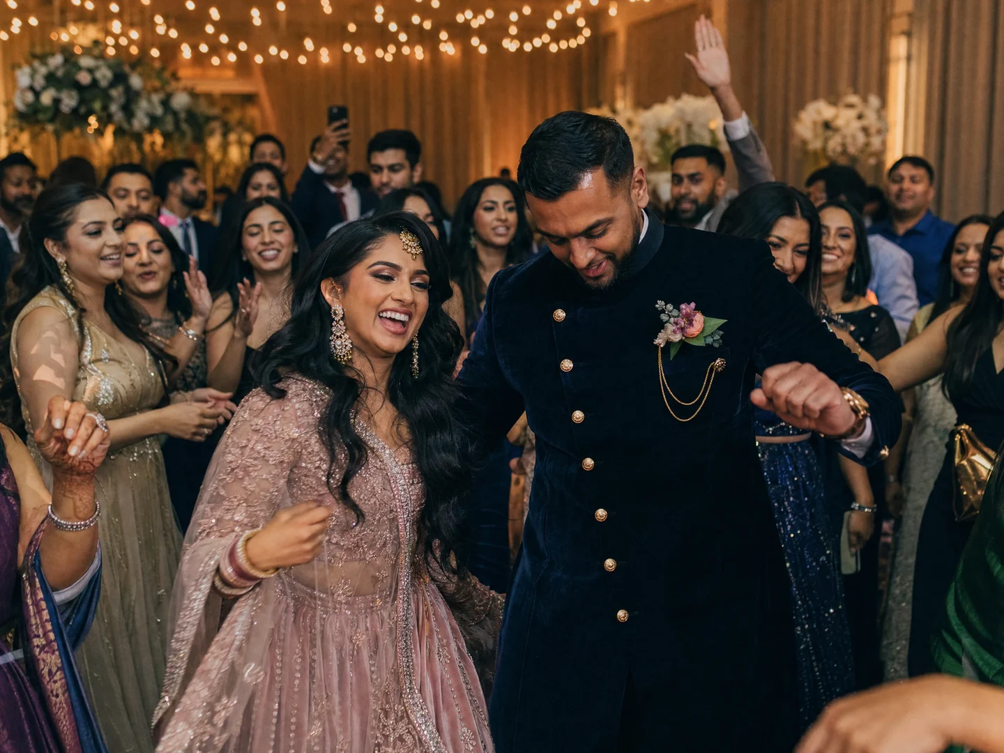 Hindoestaans bruidspaar danst tussen familie en vrienden